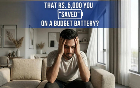 Worried man holding his head on a sofa, with text questioning the money saved on a cheap budget battery
