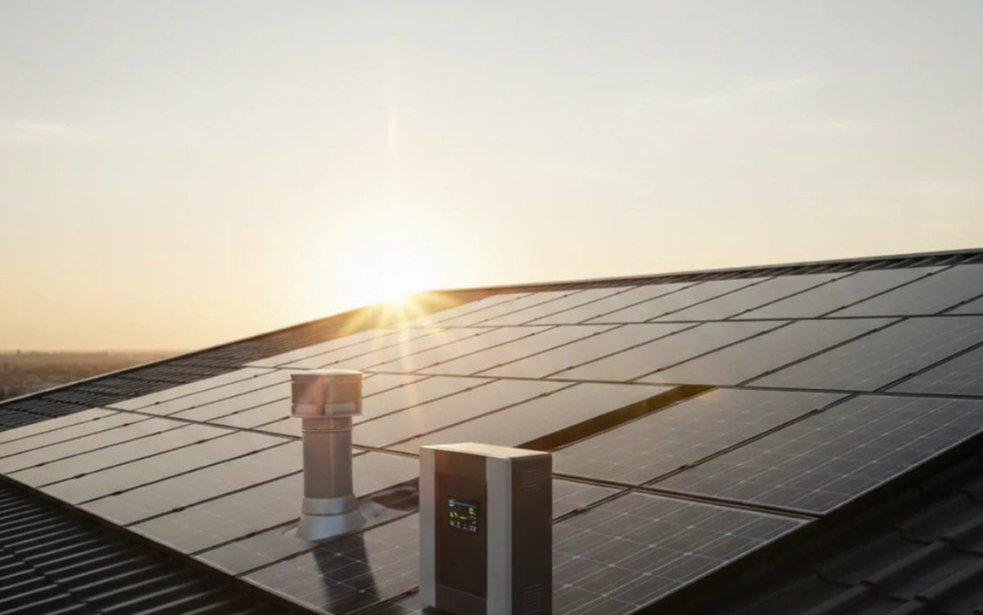 Rooftop solar panels at sunset with an inverter unit, representing solar battery maintenance for best performance